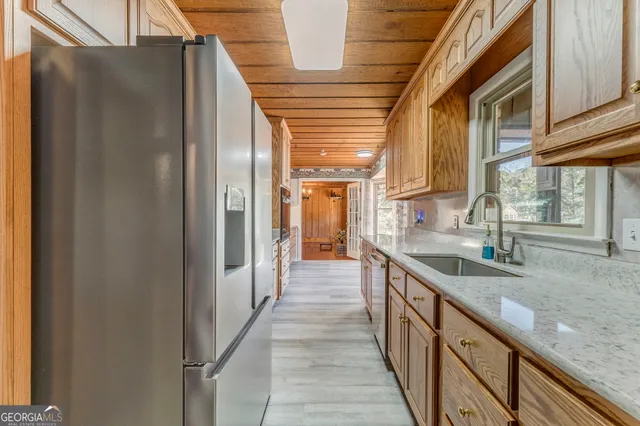 a view of an empty room with wooden floor and a fireplace