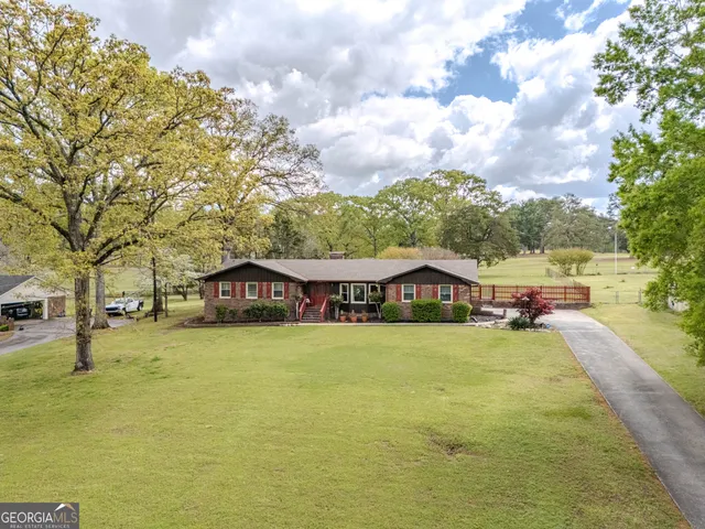 a view of a house with a yard and sitting area