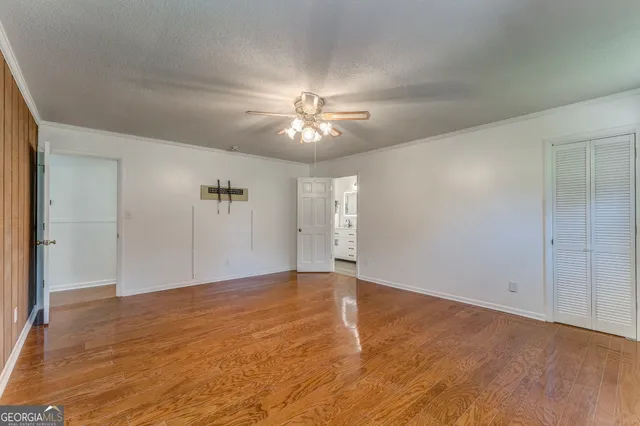 a view of empty room with wooden floor and window