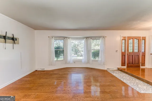 a big room with wooden floor and windows