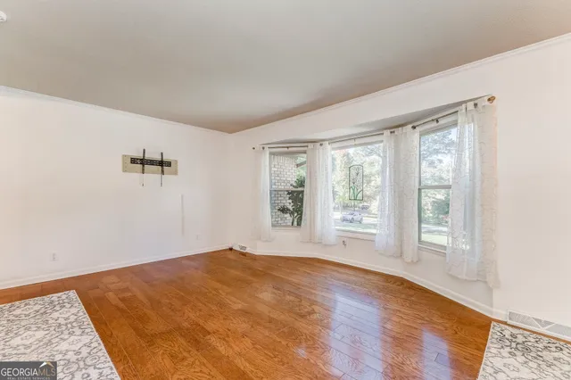 a view of a hallway with wooden floor and a bathroom