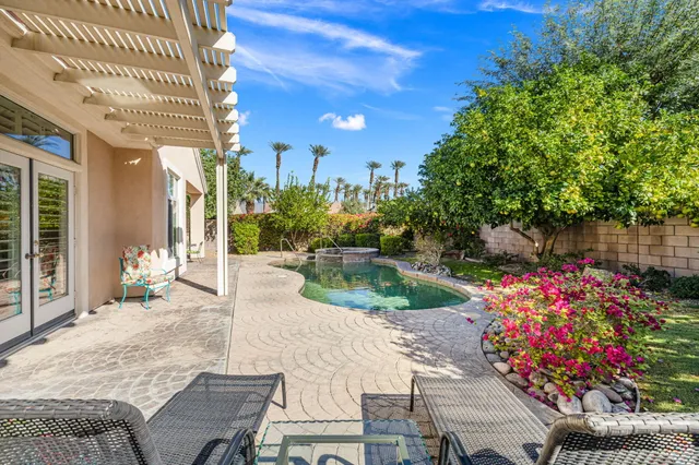a patio with table and chairs and potted plants
