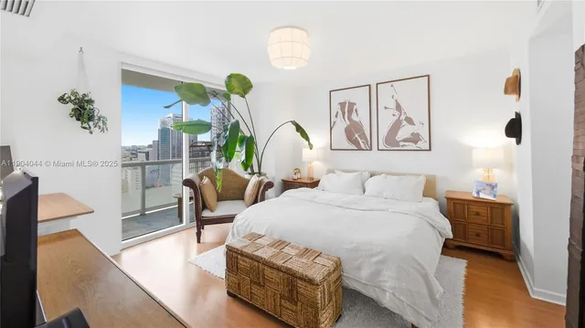 a bedroom with a bed a chandelier and painting on the wall