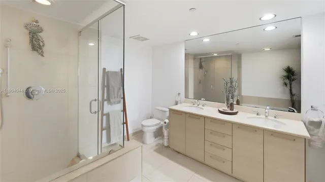 a bathroom with a double vanity sink toilet and shower