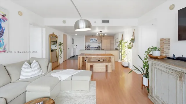 a living room with kitchen island furniture and a chandelier