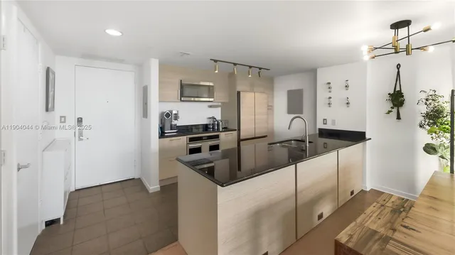 a kitchen with stainless steel appliances granite countertop a refrigerator and a sink