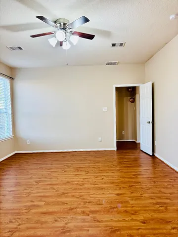 an empty room with wooden floor and windows