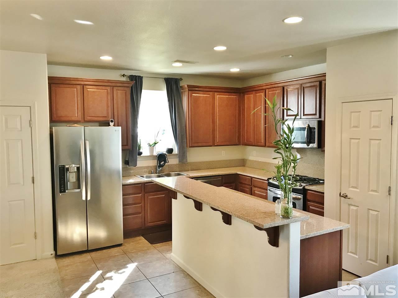 260 Brenham Avenue Reno, NV 89509 - Photo 19 of 20 a kitchen with stainless steel appliances granite countertop a refrigerator a sink a stove and a refrigerator with wooden floor