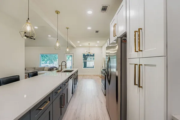 a kitchen with kitchen island a counter top space a sink stainless steel appliances and cabinets