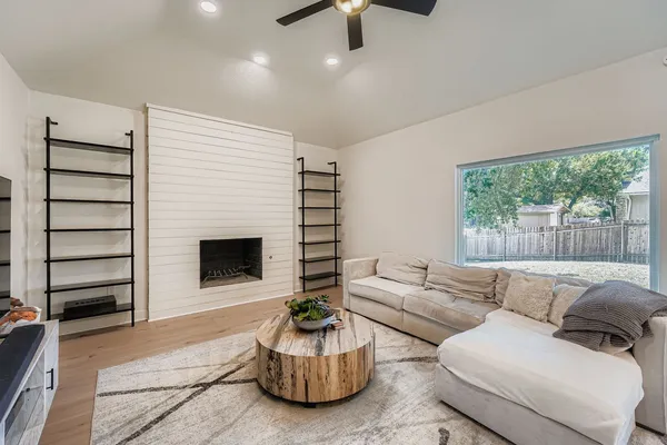 a living room with furniture a flat screen tv and a fireplace
