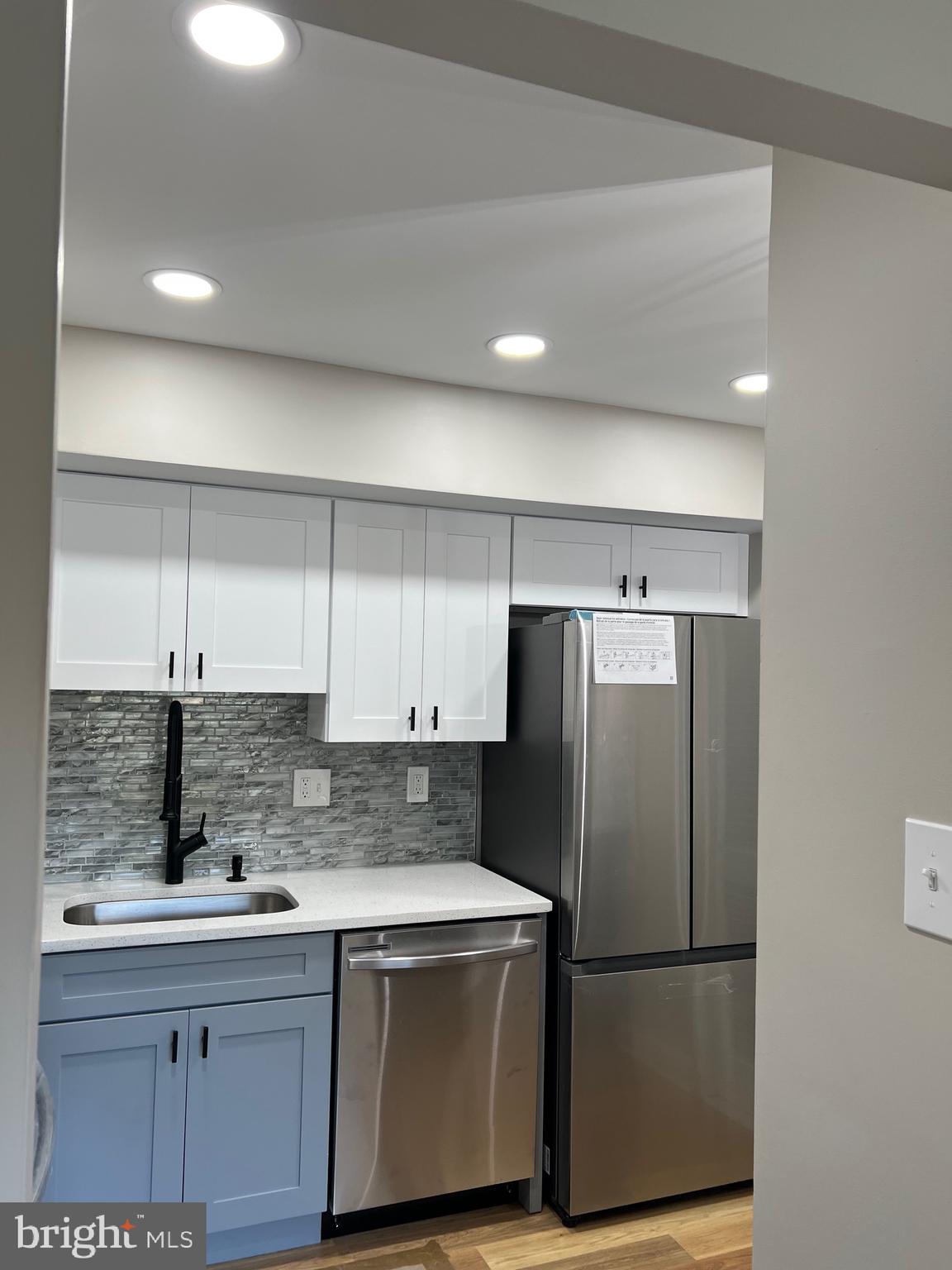 700 Ardmore Ave Ardmore Avenue, Unit 606 Ardmore, PA 19003 - Photo 19 of 32 a kitchen with stainless steel appliances granite countertop a refrigerator a sink and white cabinets