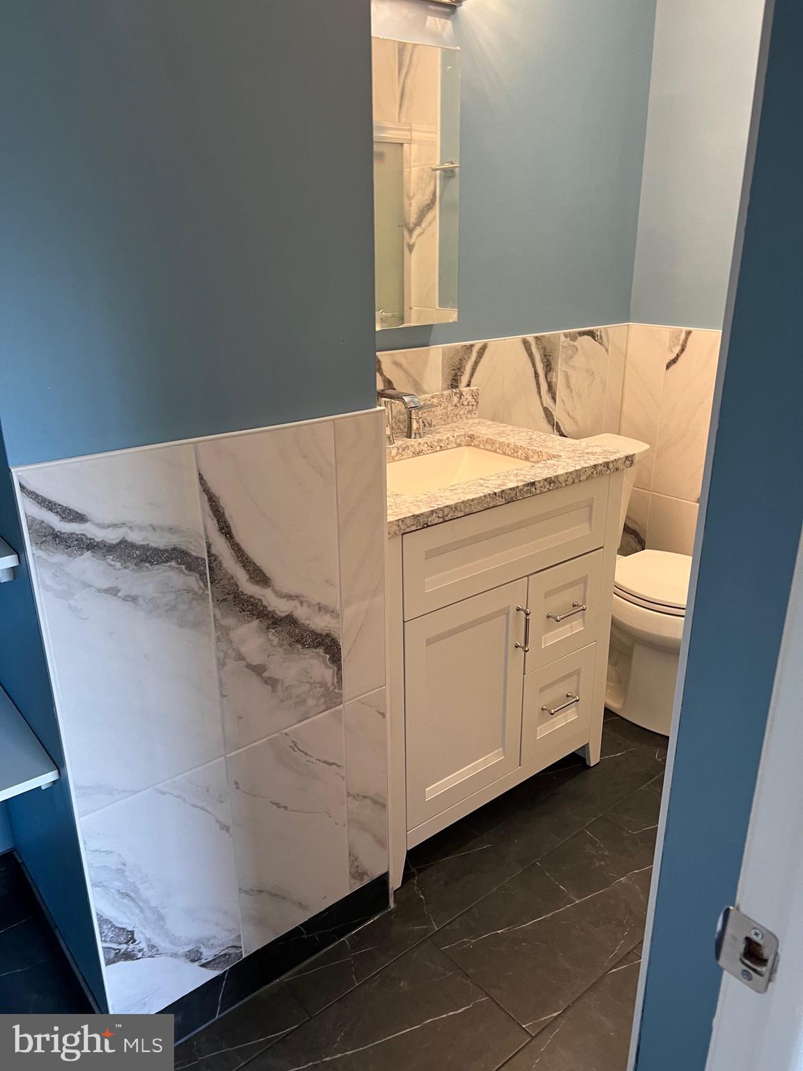 700 Ardmore Ave Ardmore Avenue, Unit 606 Ardmore, PA 19003 - Photo 27 of 32 a bathroom with a granite countertop sink and a mirror