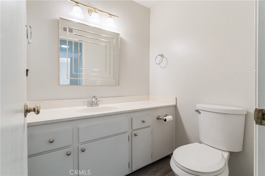 7088 Seville Way Riverside, CA 92506 - Photo 20 of 75 a bathroom with a toilet a sink a vanity and mirror