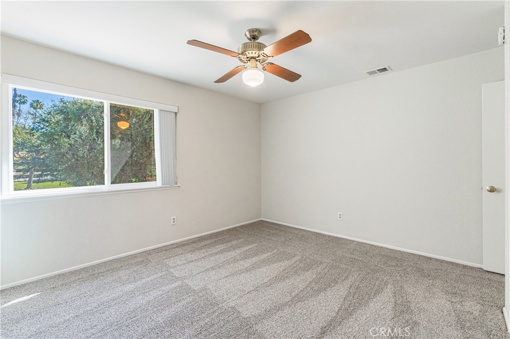 7088 Seville Way Riverside, CA 92506 - Photo 47 of 75 an empty room with a window and a ceiling fan