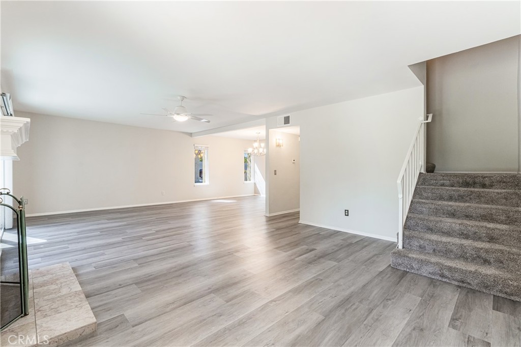 7088 Seville Way Riverside, CA 92506 - Photo 8 of 75 a view of an empty room with wooden floor and staircase