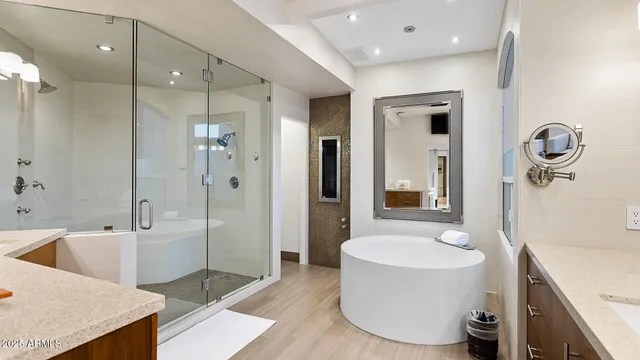 a bathroom with a tub sink shower and mirror