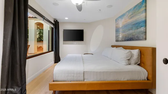 a bedroom with a large bed and a flat screen tv