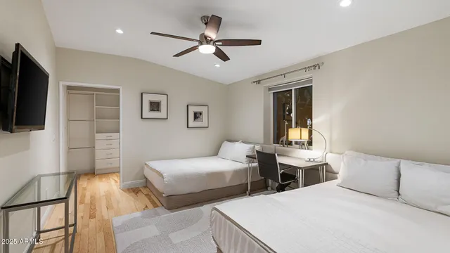 a bedroom with two beds and a flat screen tv