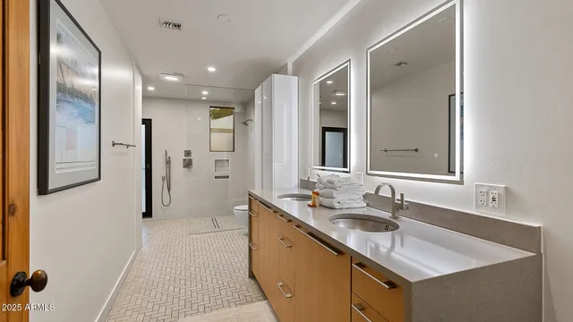 a bathroom with a double vanity sink mirror and shower