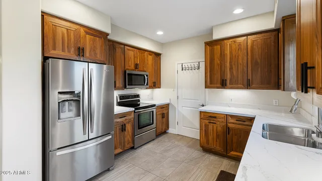 a kitchen with stainless steel appliances granite countertop a refrigerator stove microwave and sink