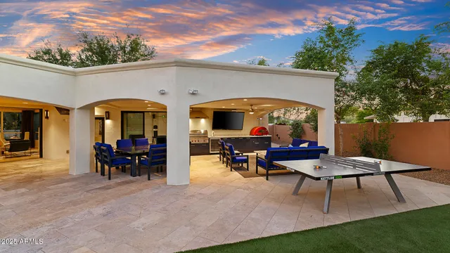 a view of a patio with dining table and chairs with a small yard
