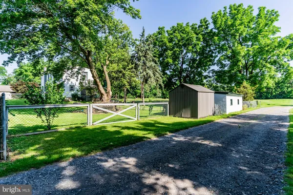 a view of a house with a yard and a large tree
