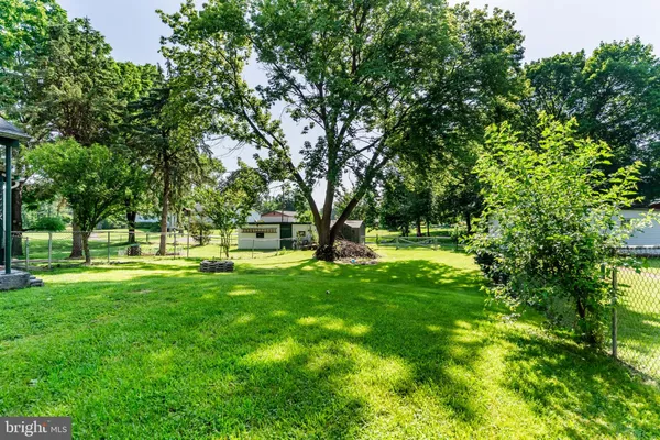a view of green field with trees in the background