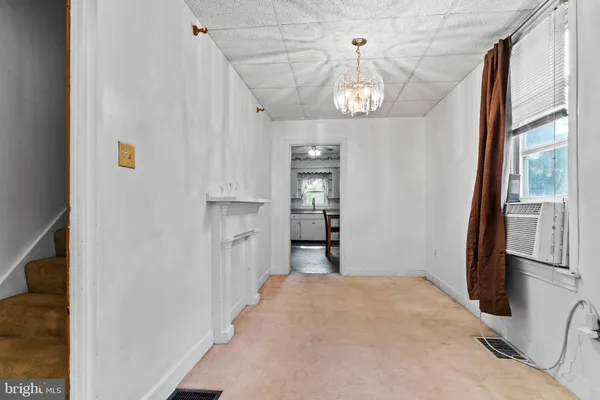 a view of a livingroom with wooden floor and a kitchen space