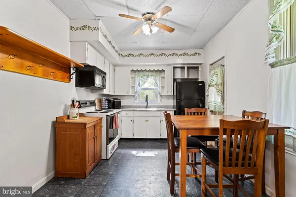 a kitchen with stainless steel appliances granite countertop a stove a sink dishwasher a refrigerator with a dining table and chairs