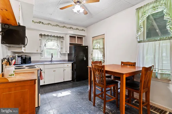a kitchen with stainless steel appliances kitchen island granite countertop a table chairs sink and microwave