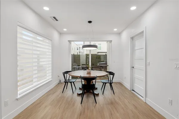 a dining room with furniture window and wooden floor