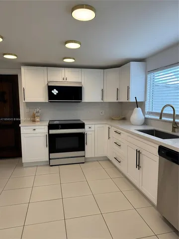 a kitchen with stainless steel appliances cabinets a sink and a stove