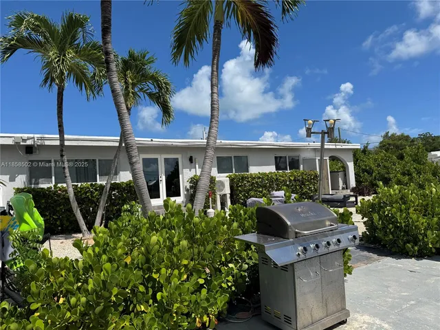 a living room with couches a fireplace and a chandelier