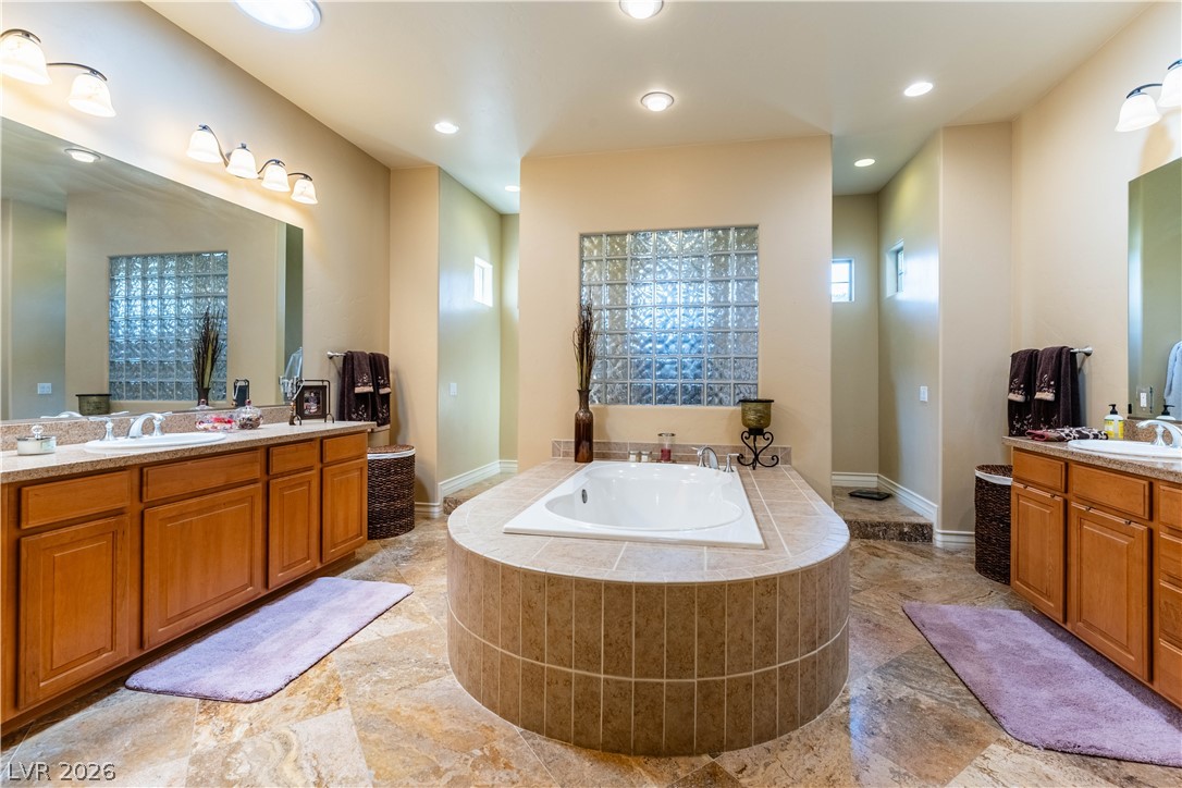 3661 Riley Ann Avenue Las Vegas, NV 89139 - Photo 31 of 42 Indulge in a luxurious primary bathroom, featuring a grand soaking tub and dual vanities.