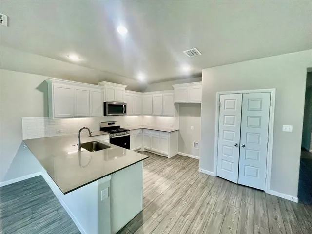 a kitchen with white cabinets sink and stainless steel appliances
