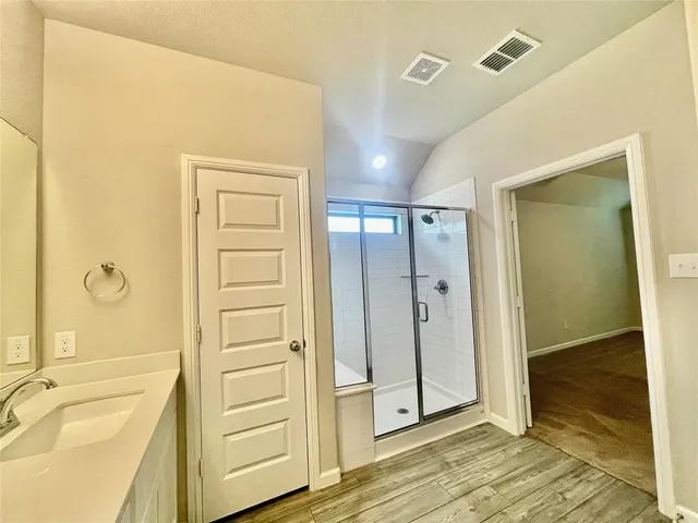 a bathroom with a tub shower and sink
