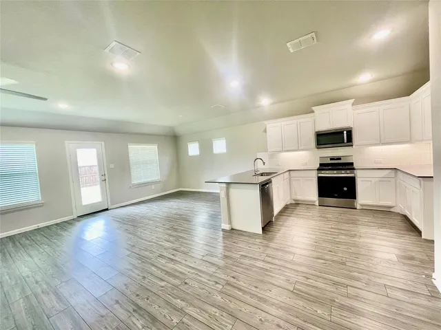 a view of kitchen with microwave and cabinets