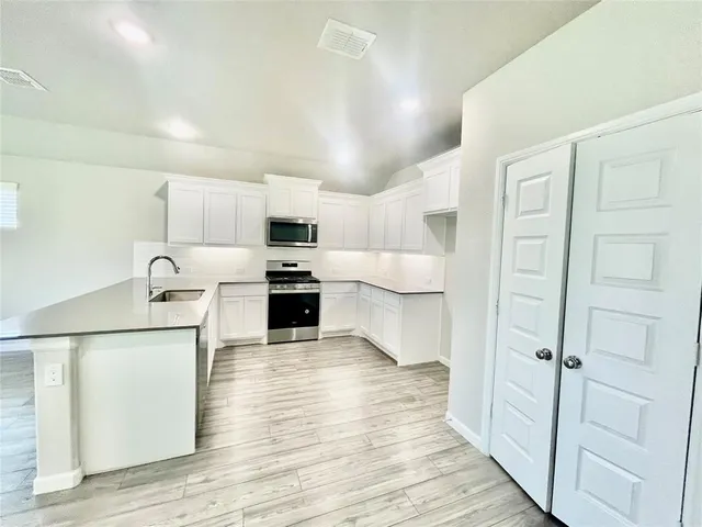 a kitchen with granite countertop a sink and steel appliances