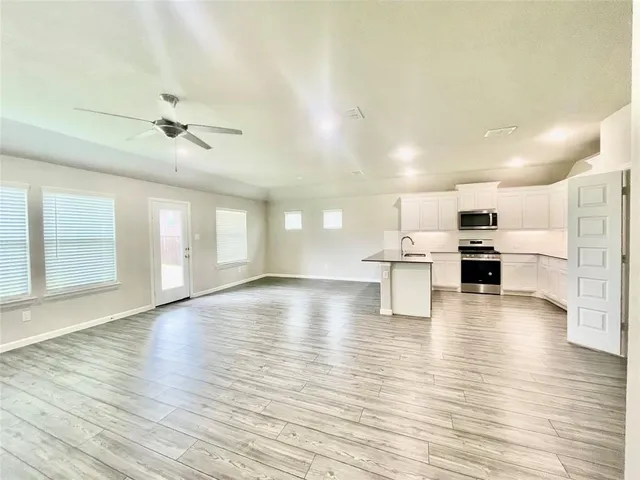 a kitchen with white cabinets and stainless steel appliances