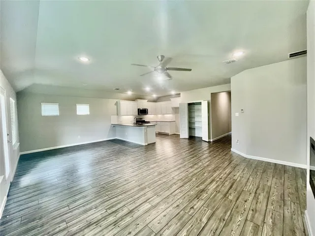 a view of large kitchen with wooden floor and electronic appliances