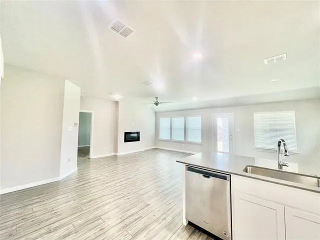 a view of a kitchen with wooden floor and electronic appliances