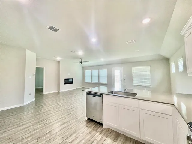 a kitchen with granite countertop white cabinets and wooden floor