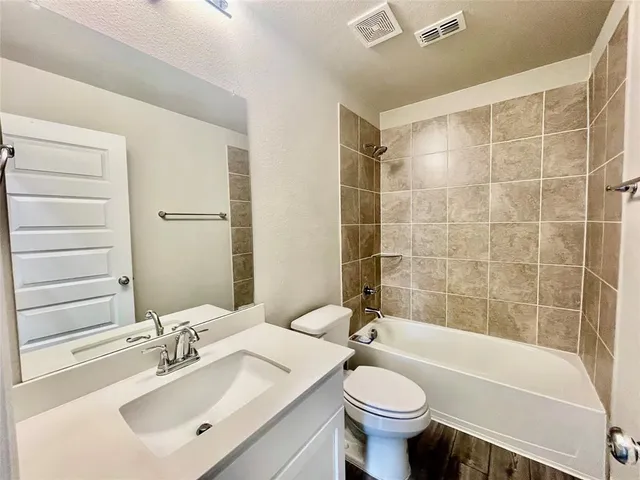 a bathroom with a sink mirror toilet and bathtub