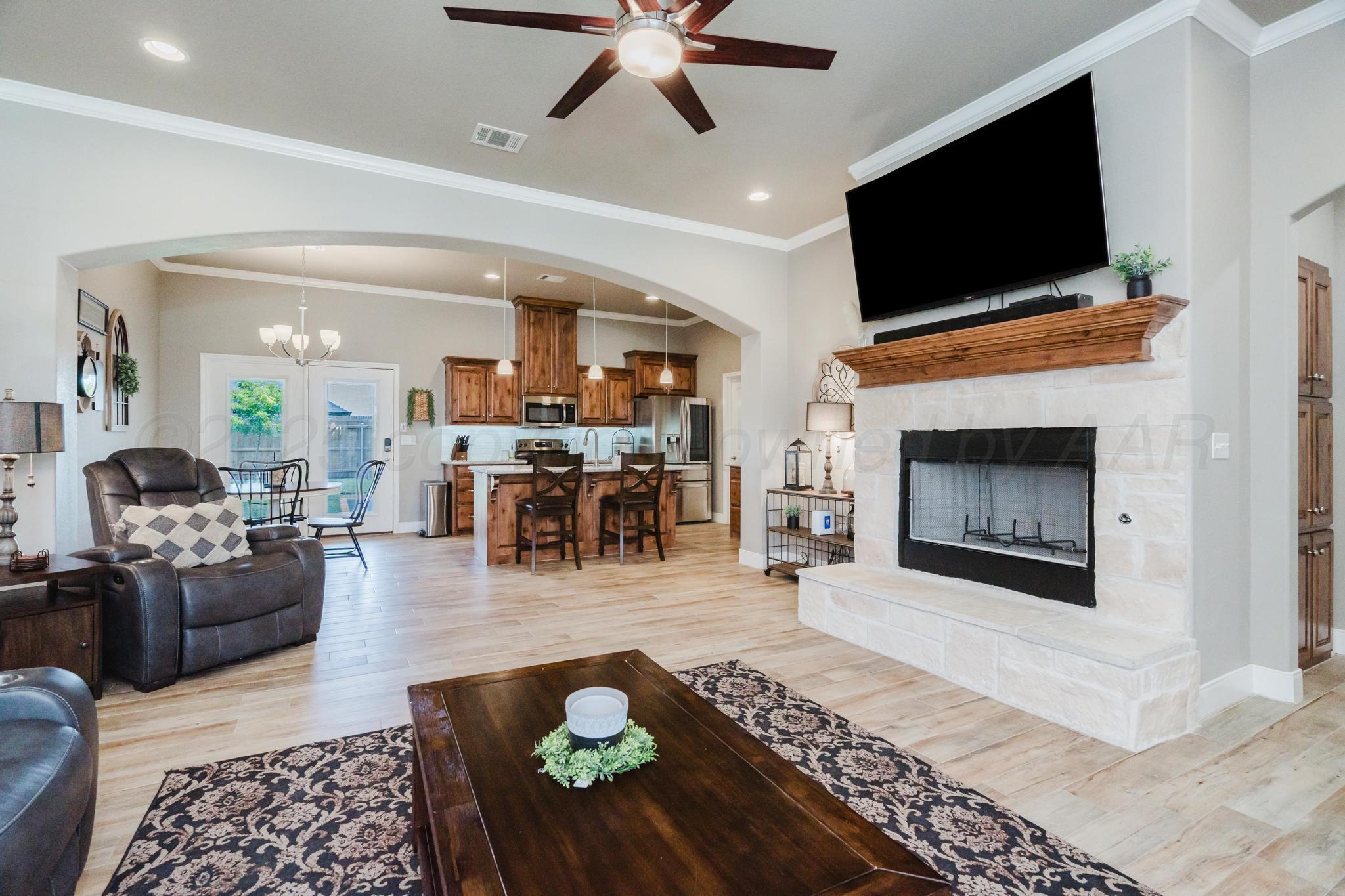 9011 Staten Island Amarillo, TX 79119 - Photo 3 of 17 a living room with furniture a fireplace and a flat screen tv