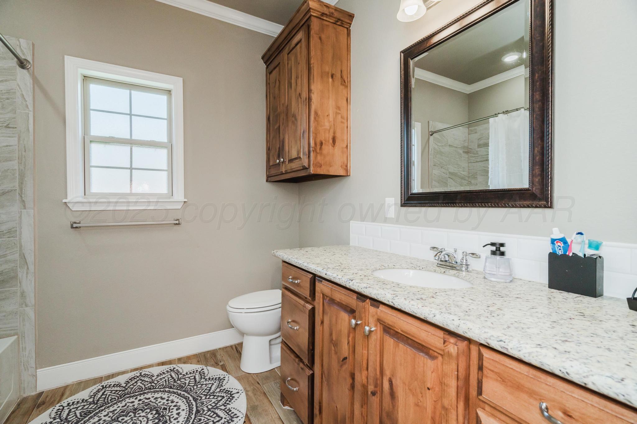 9011 Staten Island Amarillo, TX 79119 - Photo 10 of 17 a bathroom with a granite countertop sink and a mirror