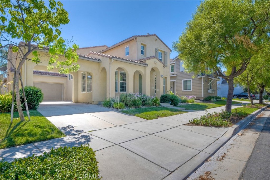 a front view of a house with a yard and potted plants