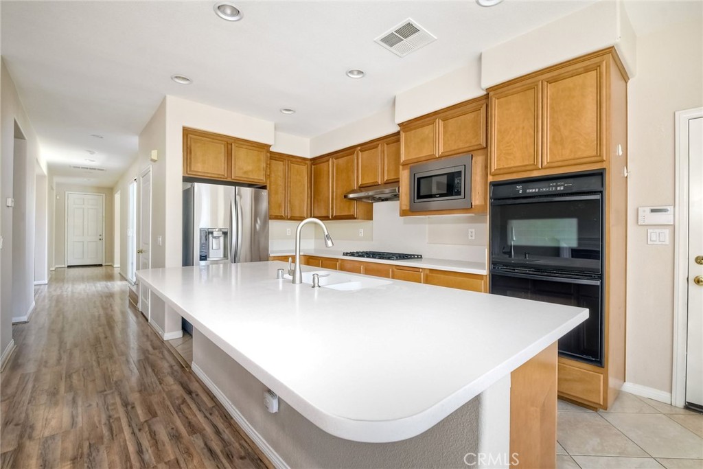 28961 Savannah Drive Temecula, CA 92591 - Photo 19 of 54 a large kitchen with stainless steel appliances a large counter top space a stove and a refrigerator