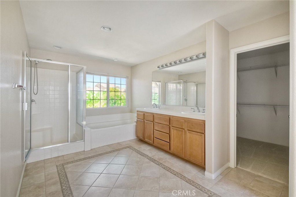 28961 Savannah Drive Temecula, CA 92591 - Photo 30 of 54 a bathroom with a granite countertop sink a mirror and a bathtub