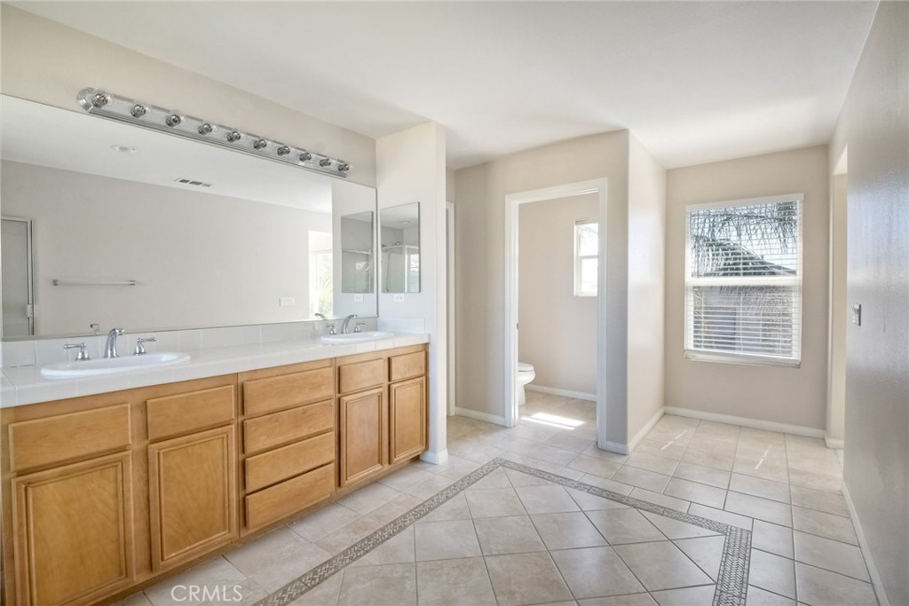 28961 Savannah Drive Temecula, CA 92591 - Photo 31 of 54 a spacious bathroom with a granite countertop sink a mirror and a bathtub