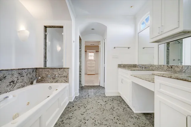 a bathroom with a granite countertop tub sink and mirror